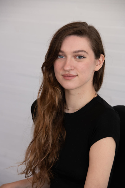 Photo of Michelle Miles, a woman with long, wavy brown hair, wearing a short sleeve black shirt