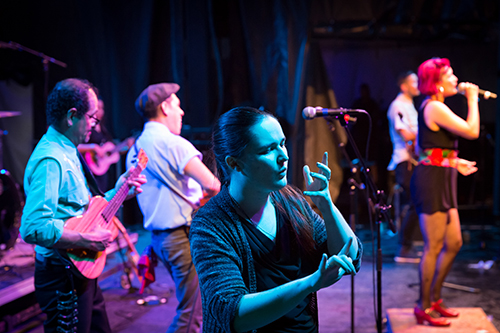ASL interpreter signing for a music performance at a festival