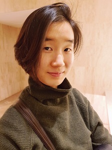 A woman who is Asian Canadian with straight chin length brown, light colored skin wearing a dark turtle neck sweater.