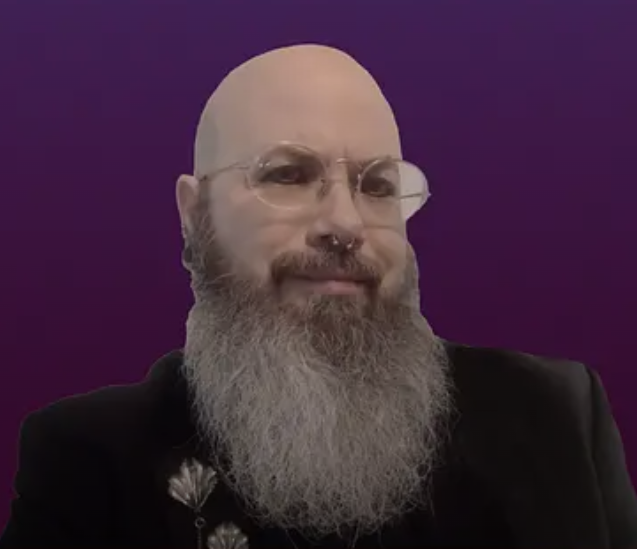 Headshot of Nicholas Love, a white, bald man with a long gray beard